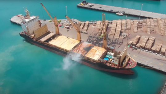 Image:An aerial photo of Kota Bahagia shows smoke from the cargo hold fire in the New Zealand port of Napier in December 2020. Image: James Hooker/TAIC