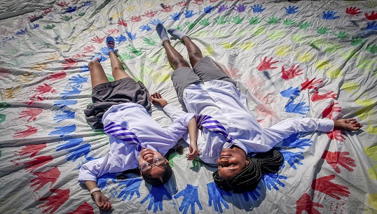 Image:The vision of 'hands around the world' joining together to remove barriers to girls receiving an education was the inspiration for creating a 'rainbow spiral' of children's handprints on one of Maiden's sails. More hands are added during Maiden's voyages. Image: The Maiden Factor