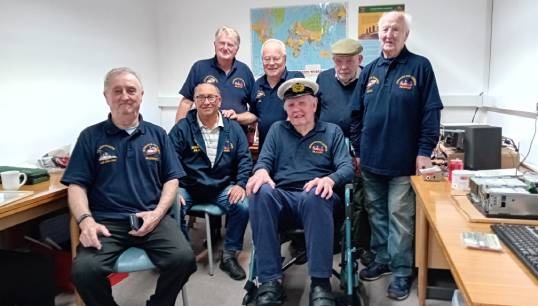Image:Stan McNally (front, wearing Merchant Navy cap) and the other radio club members celebrate the opening of their new home at Mariners' Park. Image: Nautilus International 