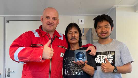 Image:Thumbs up: seafarers with a mi-fi unit. Image: Merchant Navy Welfare Board