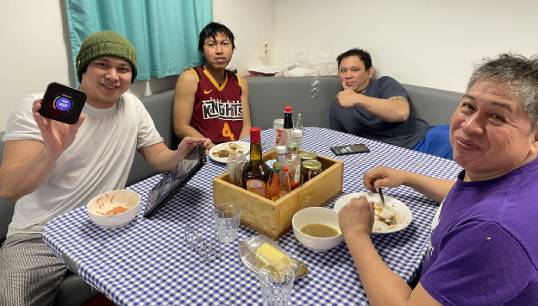 Image:Seafarers enjoying a free MiFi unit, as part of a project that has now secured vital funding for a fourth year.