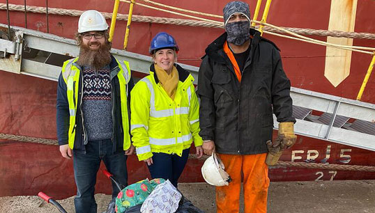 Image:Collaborative efforts: a crew member from MV Federal Tweed was among the seafarers who received gifts, with QVSR chaplain Ruth Campbell (middle) and Stella Maris chaplain Wojciech Holub (left). All images: QVSR