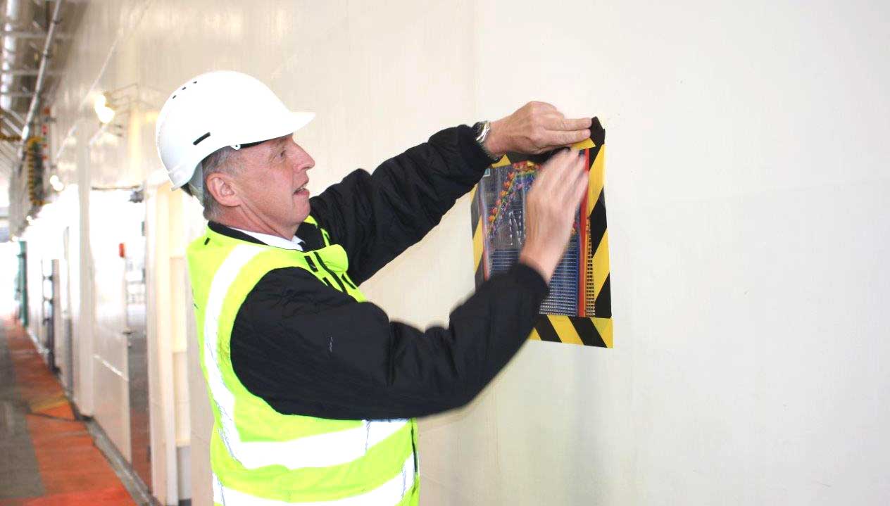 Image:A Wightlink ferry crew member fixes a poster of appreciation for crew and other essential workers created by school children in April onboard the flagship Victoria of Wight. Image: Wightlink