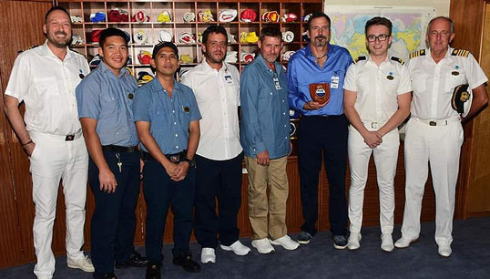 Image:Max Bingle (second from right) with the three crew who were rescued as well as colleagues and the master of the cruiseship. Image: Princess Cruises