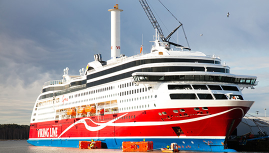 Image:The cruise ferry Viking Grace having its chimney-shaped rotor sail installed in 2018. In April 2021 it was reported that the three-year trial of the Norsepower device had been successful. Image: Viking Line 