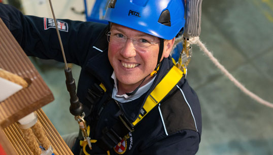 Image:Maritime minister Robert Courts climbs the ropes of a pilot ladder used to train employees who board commercial vessels, while on a visit to the Port of London Authority during maritime safety week. Image: PLA