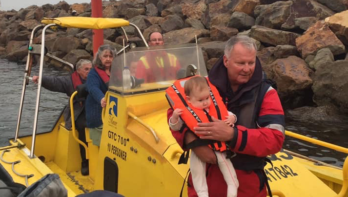 Image:AIMPE member Sean Connolly drives the Far Saracen's FRC, as a Victoria Police officer holds a baby during the Mallacoota evacuation. Seafarers from various Merchant Navy crews assisted their Australian firefighting colleagues on the ground by helping with coastal evacuations during the height of the bushfire emergencies. Image: courtesy Far Saracen crew members