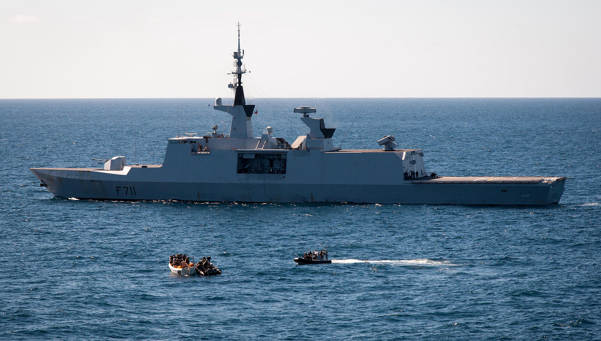 Image:EU Naval Force French Frigate Surcouf and NATO Warship USS Halyburton work together to apprehend twelve suspected pirates. Credit EUNAVOR Flickr album – EU Naval Force Actions