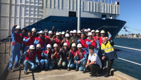 Image:The crew of the Yangtze Fortune, pictured with ITF volunteer Graham 'Yappy' Archer (right). They returned home after a five month long abandonment ordeal following intervention from the ITF. Image: ITF