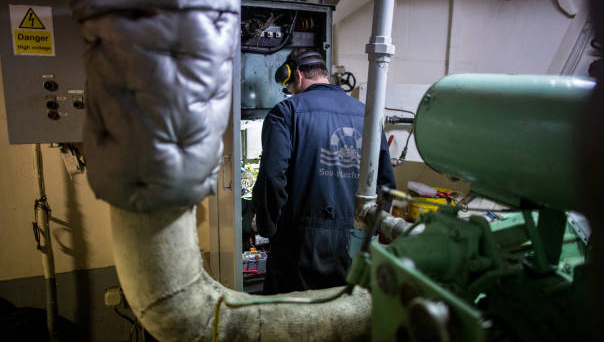 Image:The Dutch-flagged Sea-Watch 3 NGO vessel's chief engineer works on an electrical panel following an anchor winch failure on 30 January 2019 off Syracuse, Sicily. Photo: Federico Scoppa/AFP/Getty Images