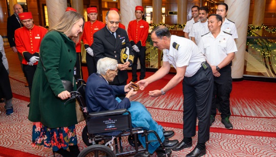Image: Queen Mary 2's bosun presenting his 102-year-old wartime counterpart John Davies with a brass bosun's whistle. Image: Cunard Line