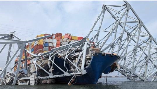 Image:Bridge trusses lying across the container ship Dali. Image: David Adams/Wikimedia Commons

