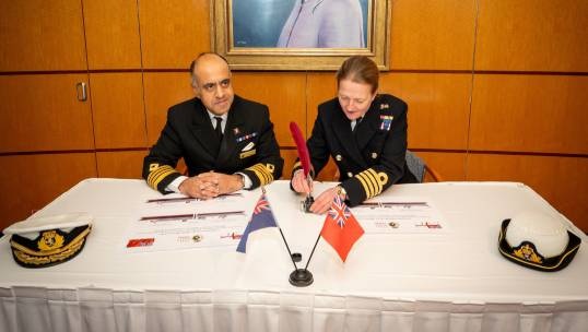 Image:Queen Mary 2 master Captain Aseem Hashmi MNM signs the affiliation agreement with HMS Queen Elizabeth's commanding officer Captain Claire Thomson OBE RN. Image: Courtesy of Capt Hashmi