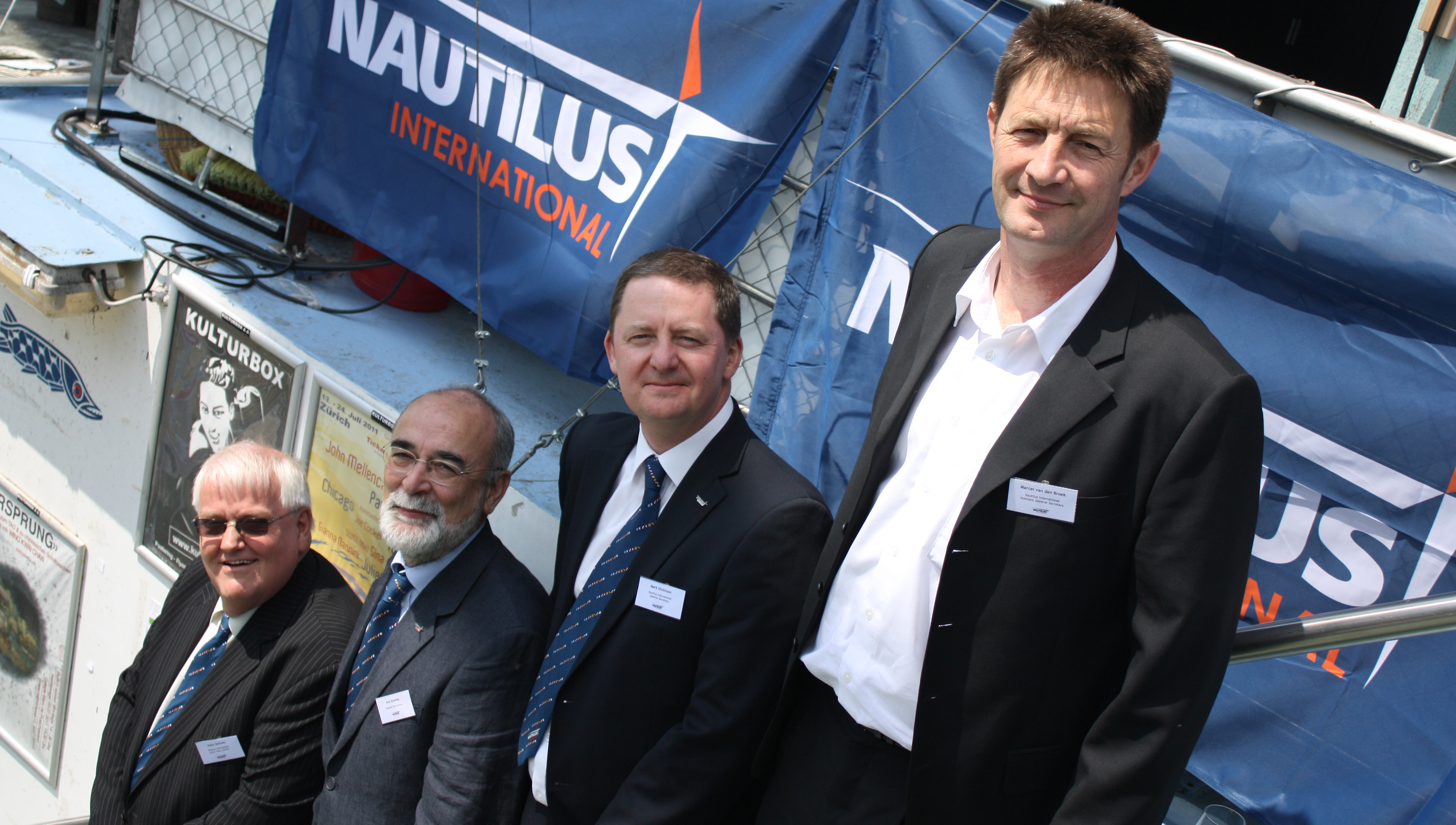 Image:Ten years at the top from left: Peter McEwen, a former deputy general secretary, Nick Bramley former head of the Swiss branch, Mark Dickinson current general secretary, Marcel van den Broek current deputy general secretary Netherlands branch.