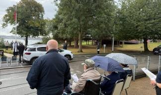 Image:Residents braving the wet weather outside the Trinity House Hub during the service 