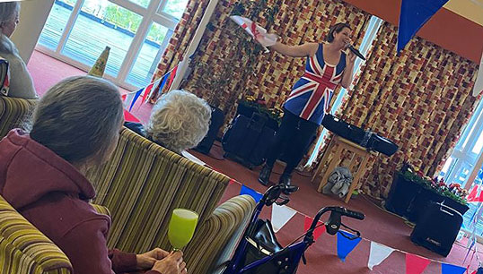 Image:Sandra Currie leads the Nautilus Mariners' Park Care Home residents' VE Day sing-along. 